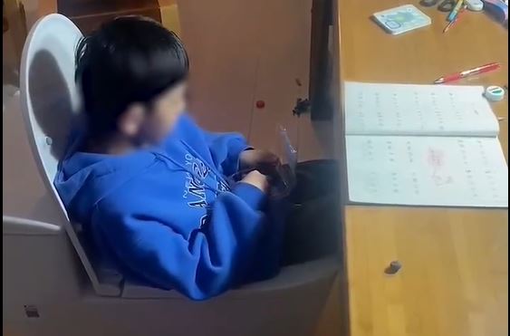 Ông bố cho con ngồi trên… bồn cầu học bài vì con trai cứ ngồi vào bàn học là đòi đi vệ sinh - ảnh 1