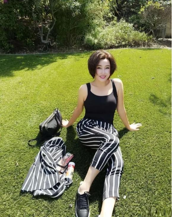 Lưu Hiểu Khánh U70 chụp ảnh selfie trên bãi cỏ, diện áo dây, quần sọc trông như ''thiếu nữ xinh đẹp'', dân tình si mê - ảnh 1