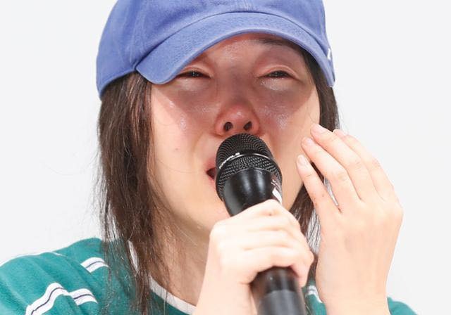 Bức hình bị cõi mạng châm biếm: Người phụ nữ quậy đục Kpop cúi gằm mặt trước rừng ống kính, nước mắt 