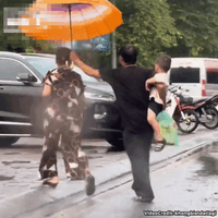 Góc đáng yêu: Mải che mưa cho vợ, cụ ông quên béng đứa cháu trai bồng trên tay