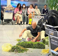 Bức ảnh khách tây vô tư ngồi nhặt rau ở sảnh sân bay Nội Bài gây xôn xao mạng xã hội