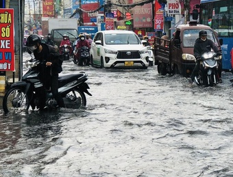 Đường TP.HCM ngập sau mưa lớn 30 phút, người dân lội nước thối